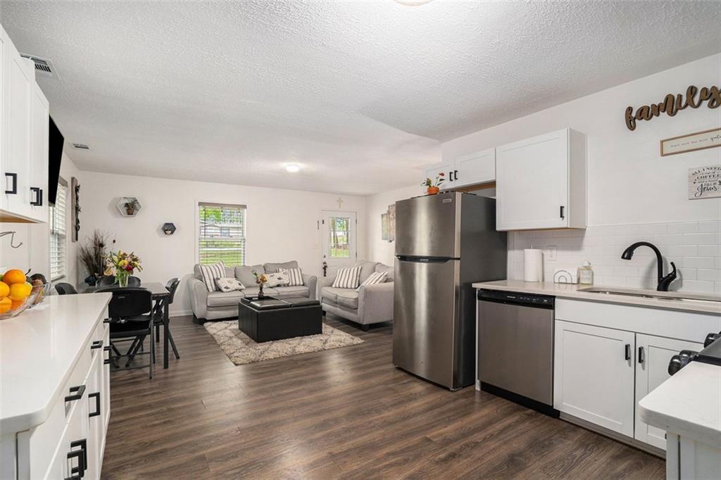 a kitchen with a refrigerator and wooden floor