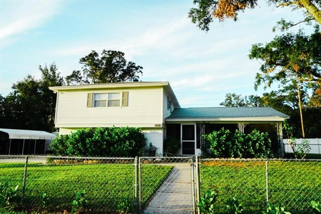 a view of a house with backyard and a garden