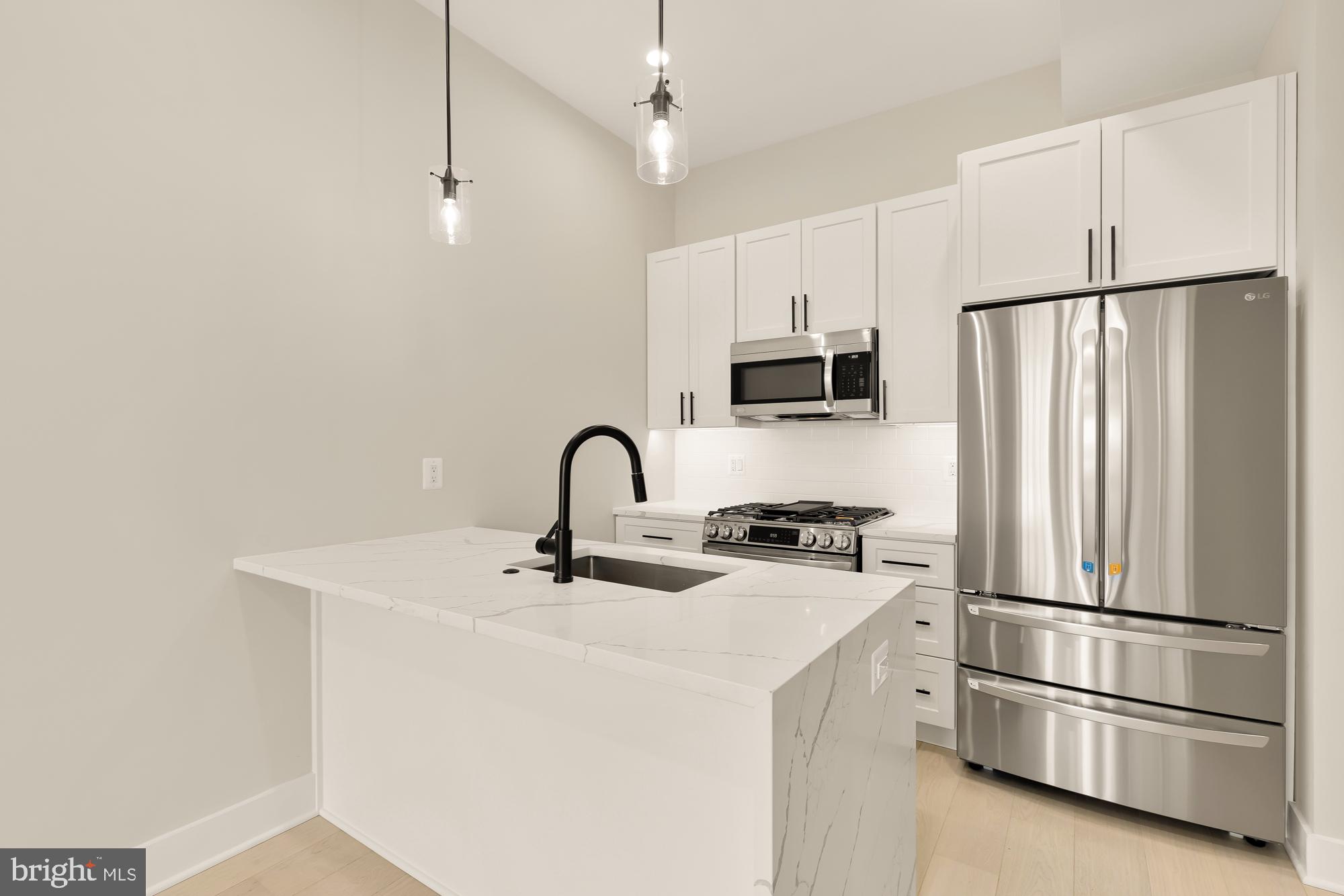 a kitchen with stainless steel appliances a refrigerator sink and cabinets