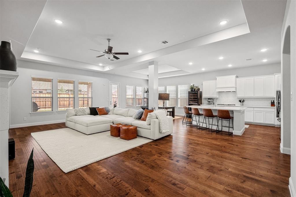 a living room with furniture wooden floor and a kitchen view