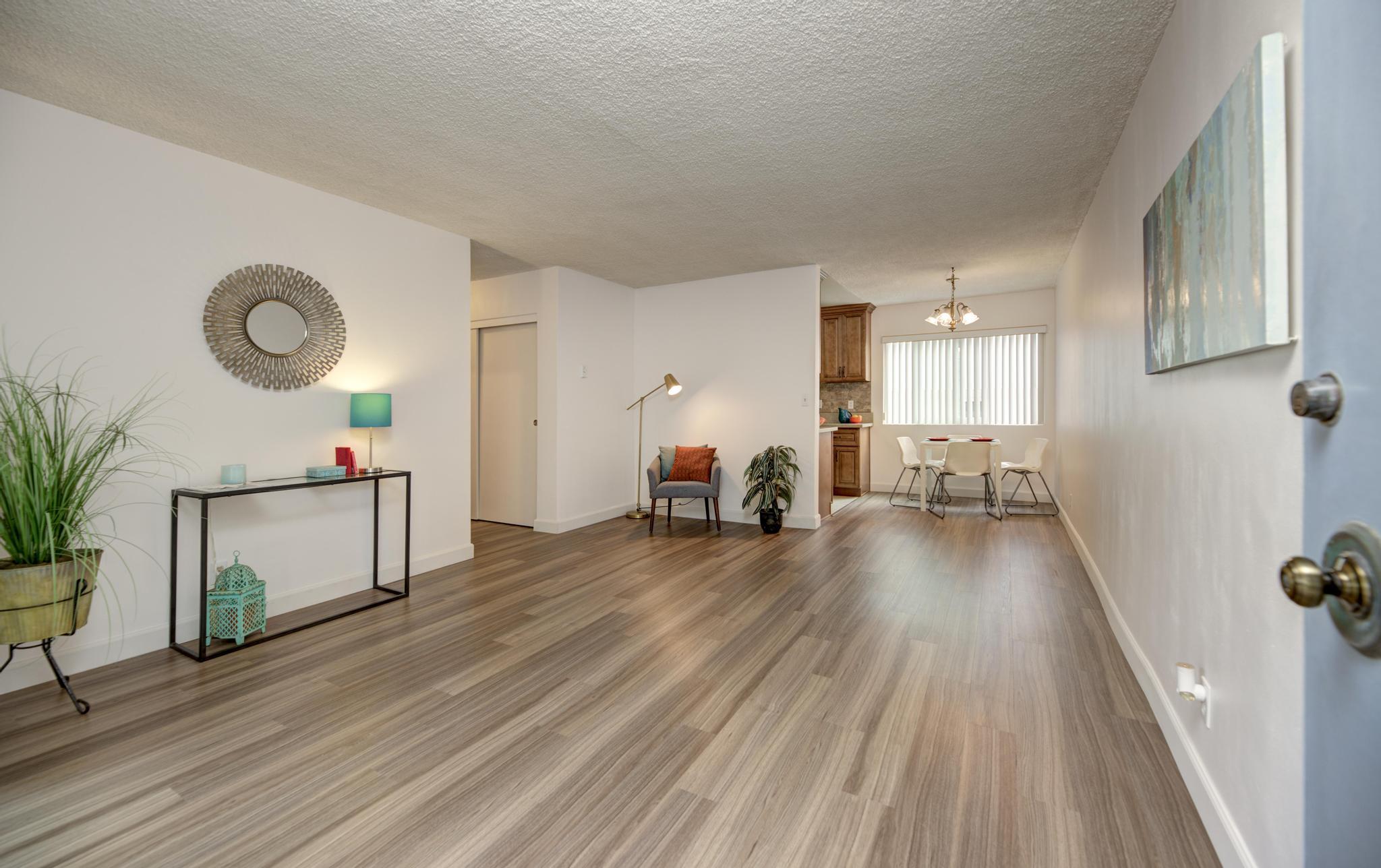 a living room with furniture and a wooden floor