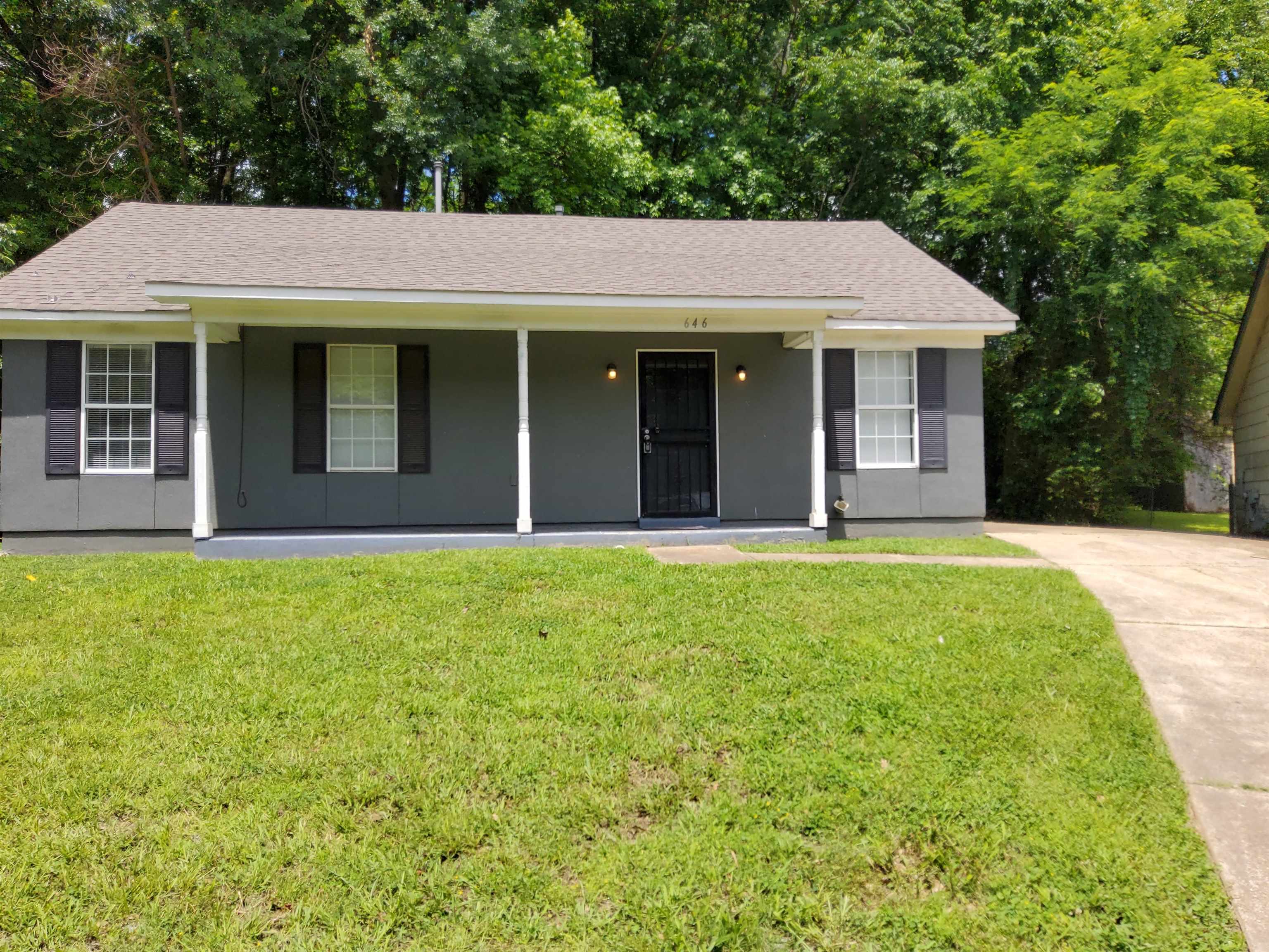 Ranch-style house with covered porch and a front yard