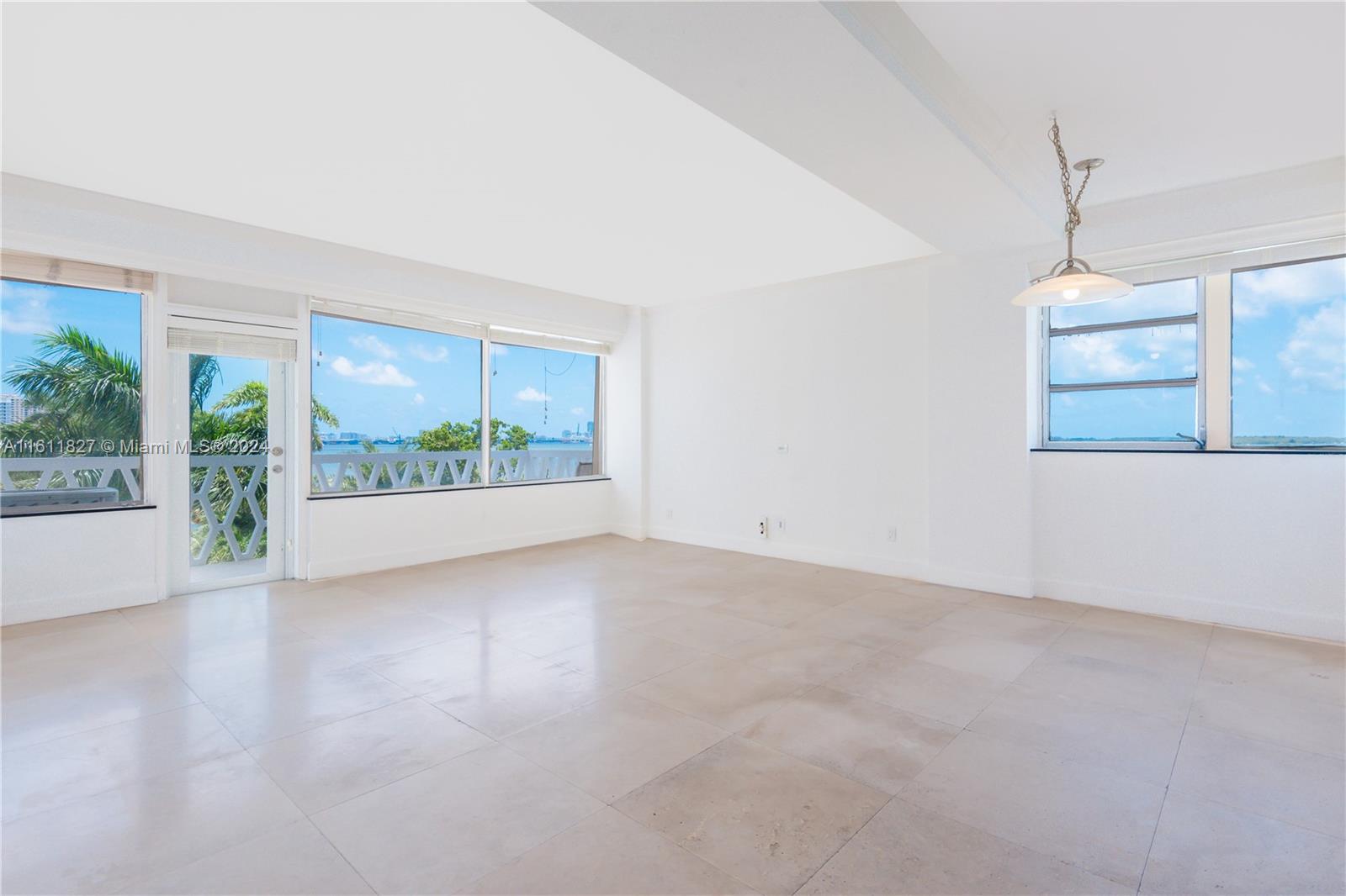 an empty room with windows and outdoor view