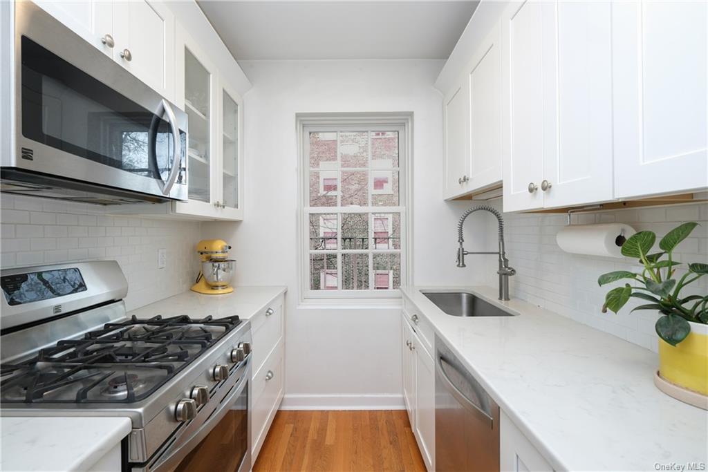 a kitchen with stainless steel appliances a sink a stove and cabinets