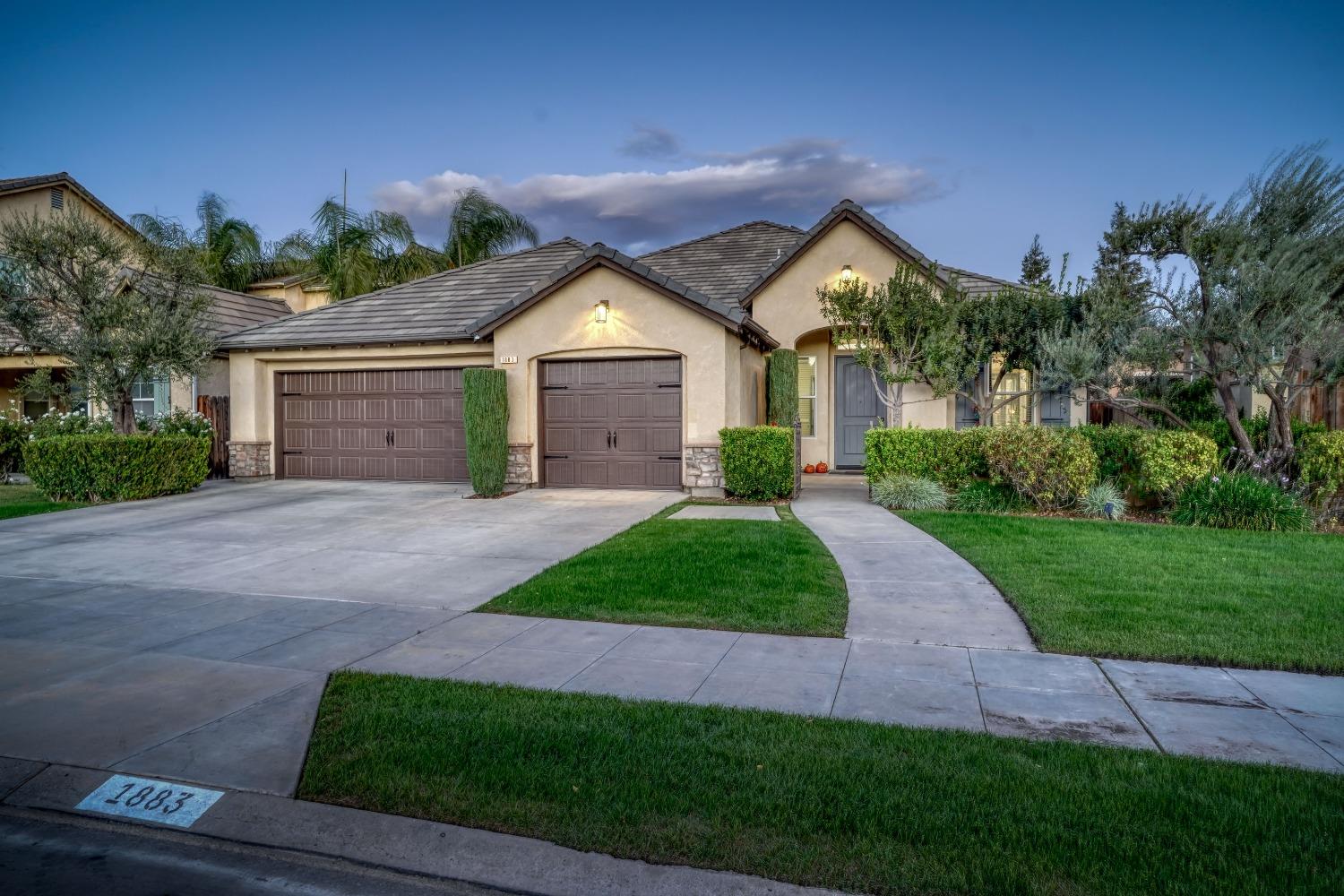 a front view of a house with yard and green space