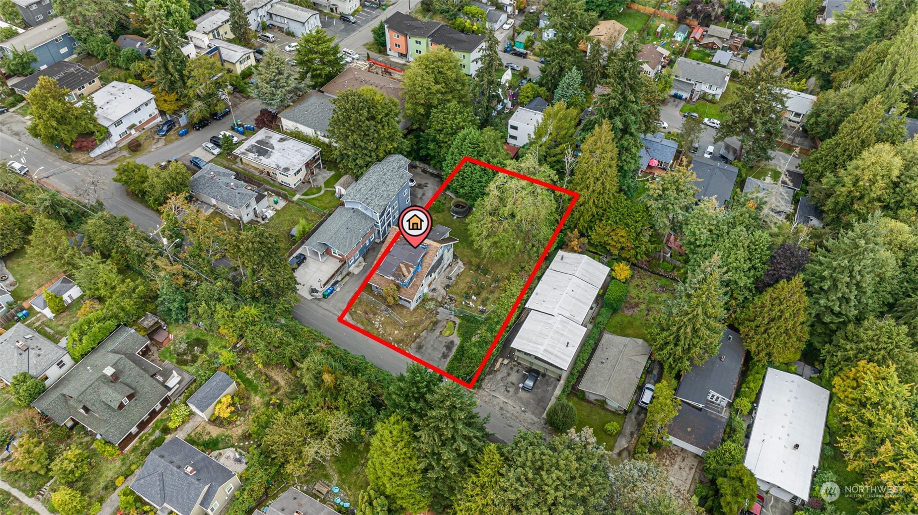 an aerial view of residential house with outdoor space and trees all around