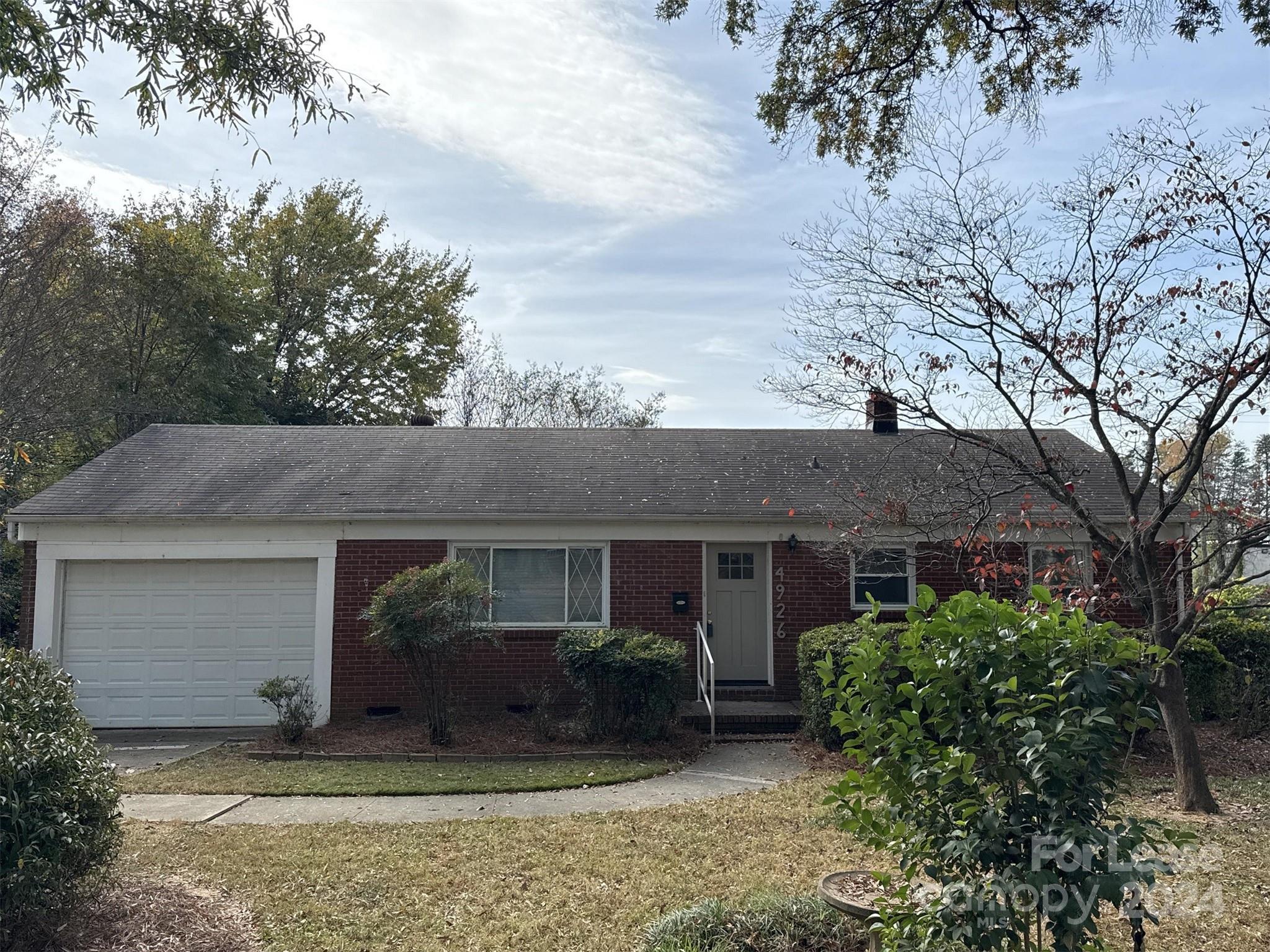 front view of a house with a yard and potted plants