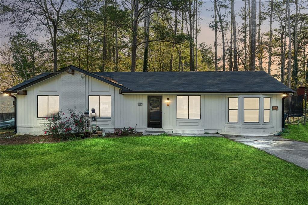 a front view of a house with a yard and trees