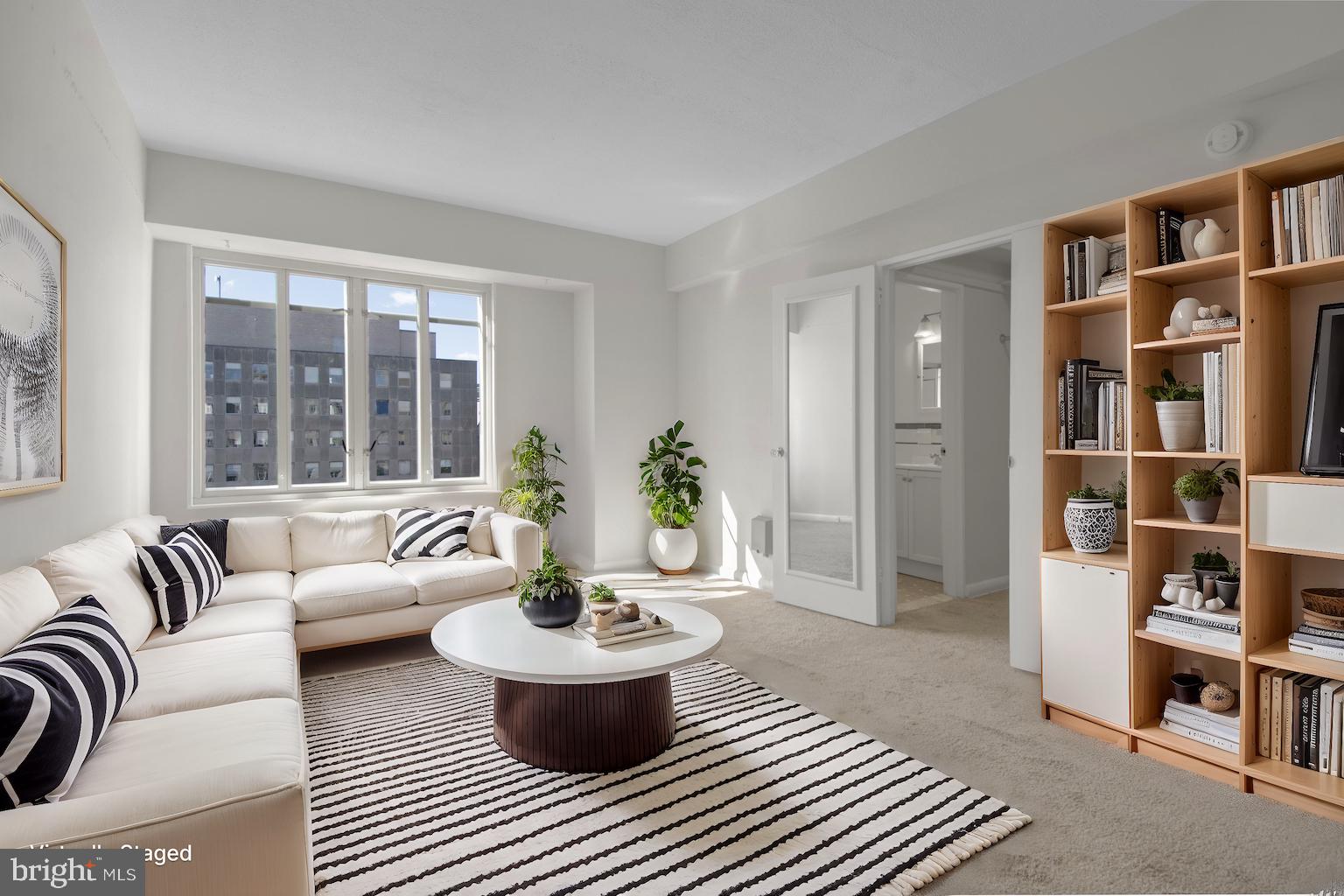 a living room with furniture and a book shelf