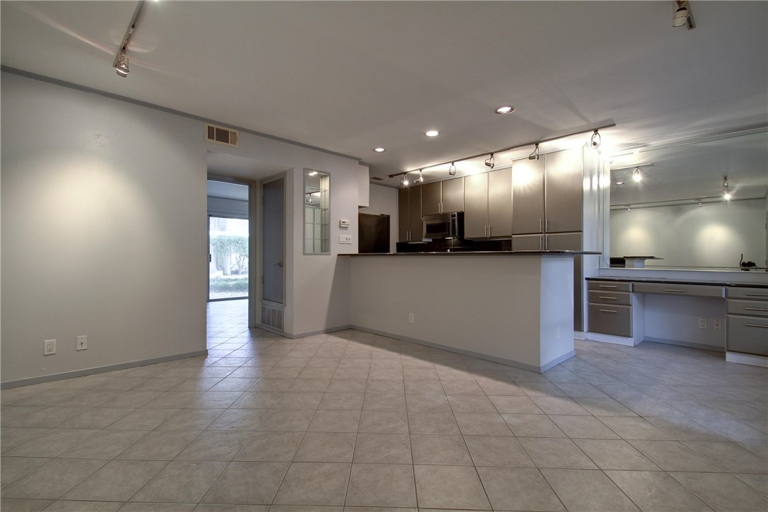 a view of a big room with wooden floor and a kitchen