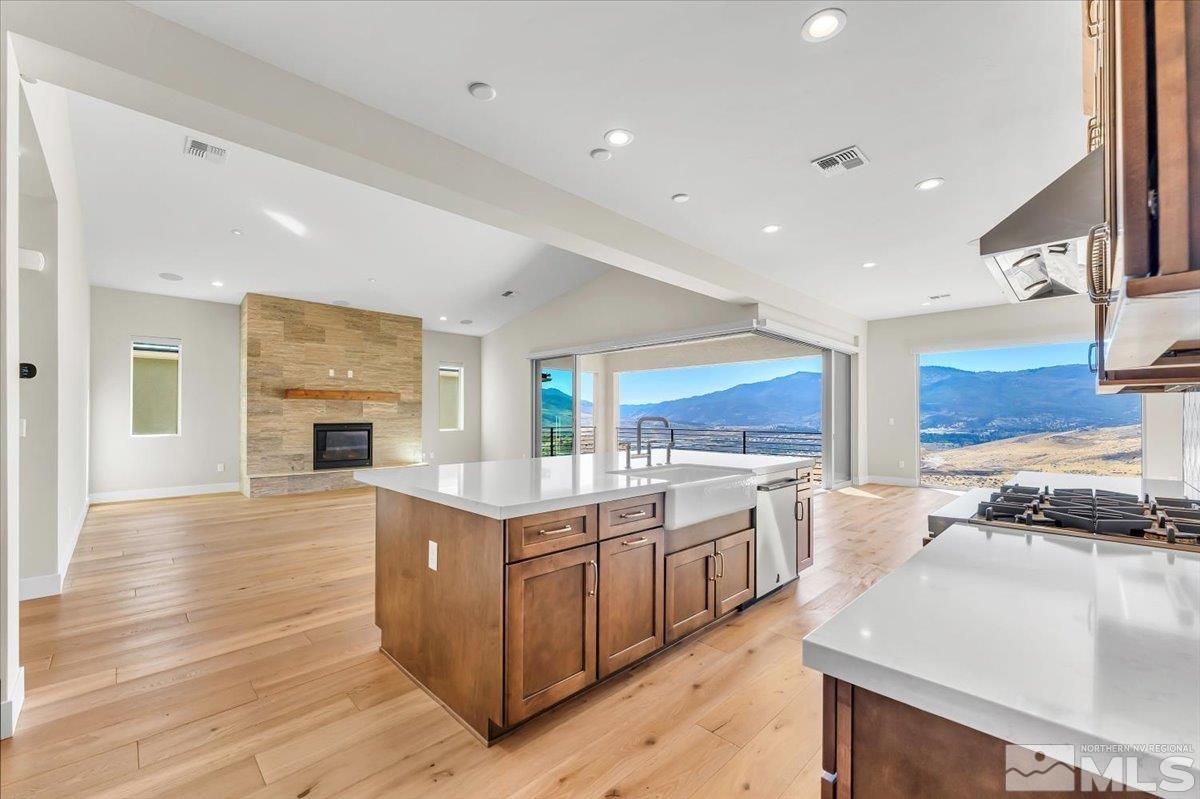 a large kitchen with stainless steel appliances granite countertop a lot of counter space and wooden floors