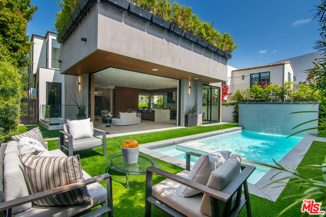 a patio with a table and chairs and potted plants