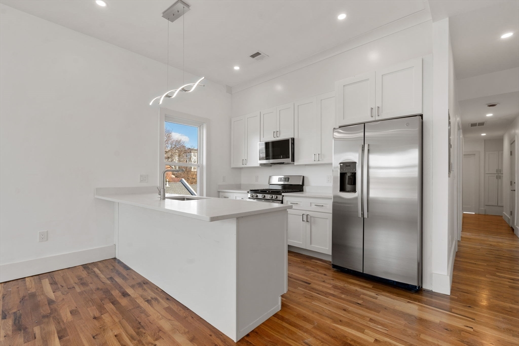 a kitchen with stainless steel appliances a refrigerator sink and microwave