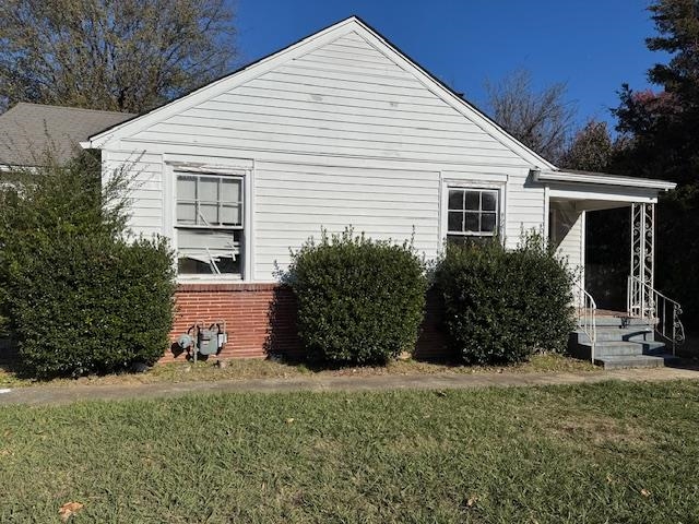 View of side of home with a yard