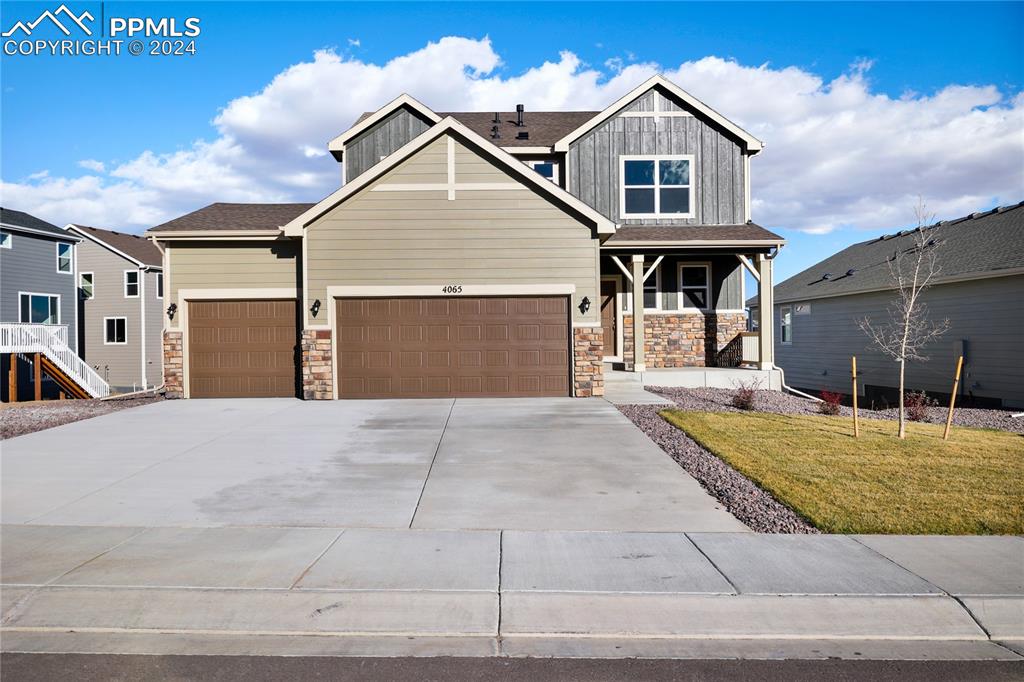 Craftsman inspired home with a garage and a front lawn