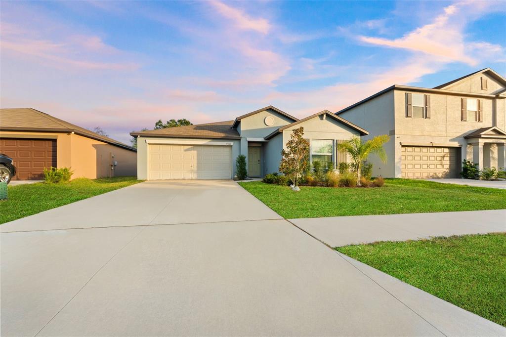 a front view of a house with a yard and garage