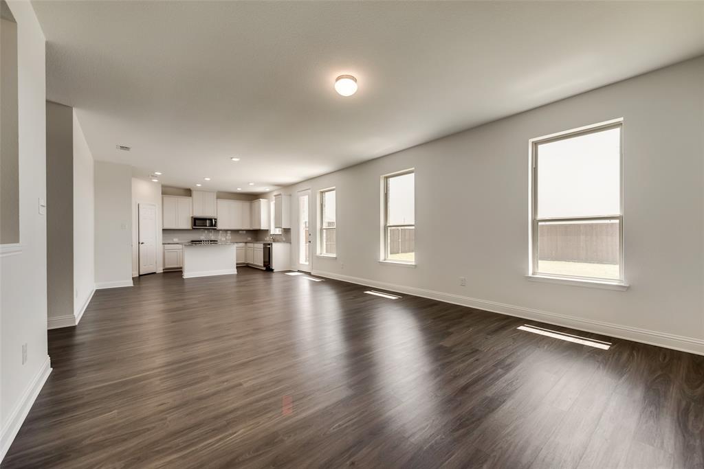 a view of a kitchen with a kitchen island wooden floor wooden floor and a window