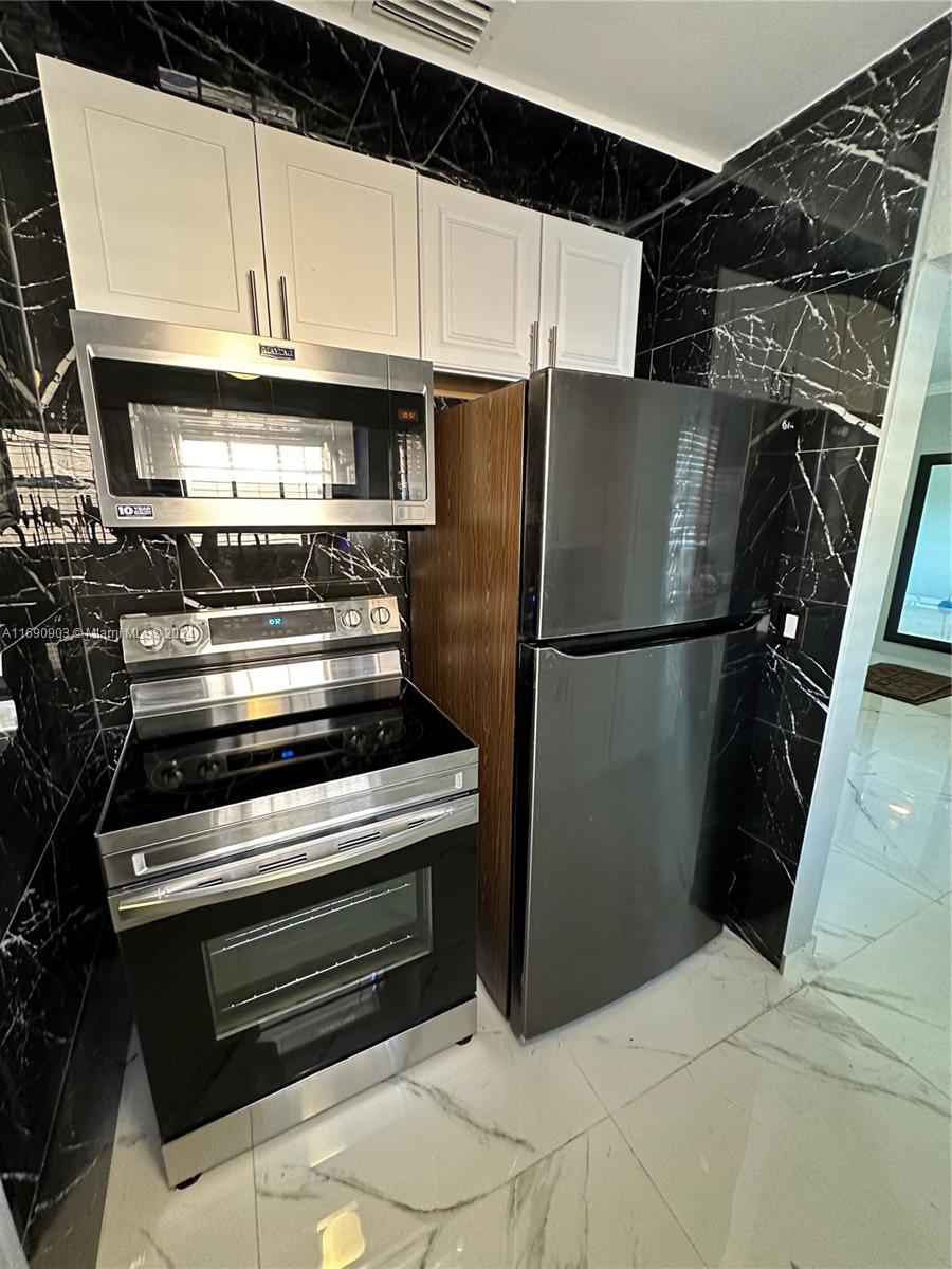 a kitchen with a refrigerator and a stove