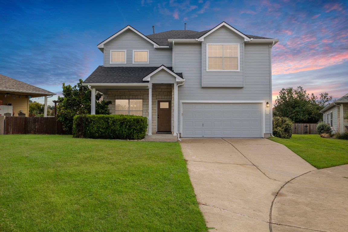 a front view of a house with a yard and garage