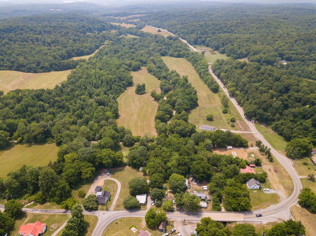 an aerial view of a house with a yard and lake view in back