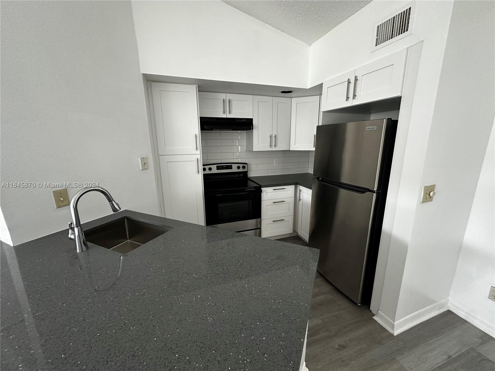 a kitchen with stainless steel appliances a refrigerator and a stove