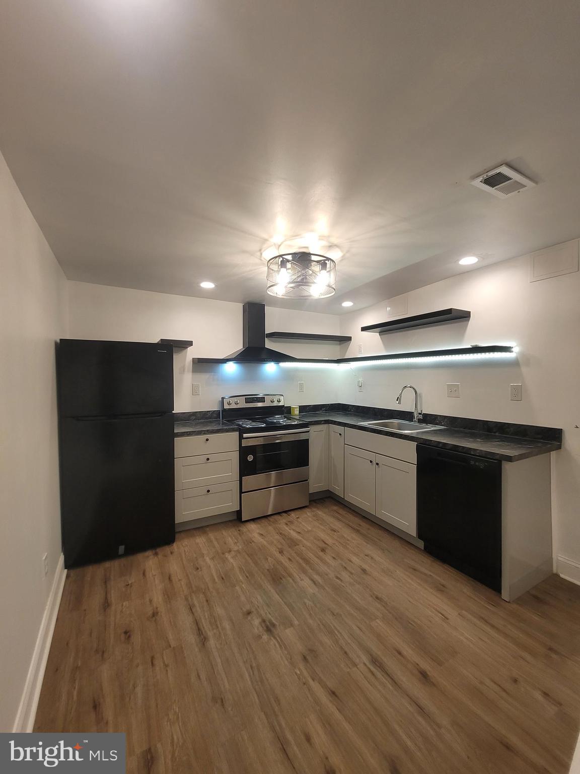 a kitchen with stainless steel appliances granite countertop a refrigerator and a stove