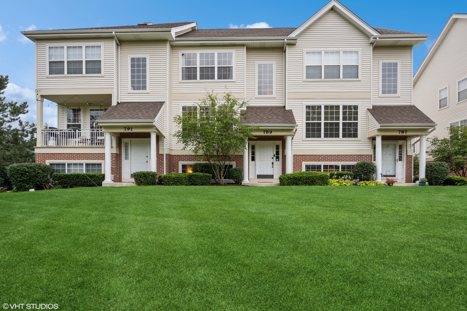 a front view of a house with a yard and trees