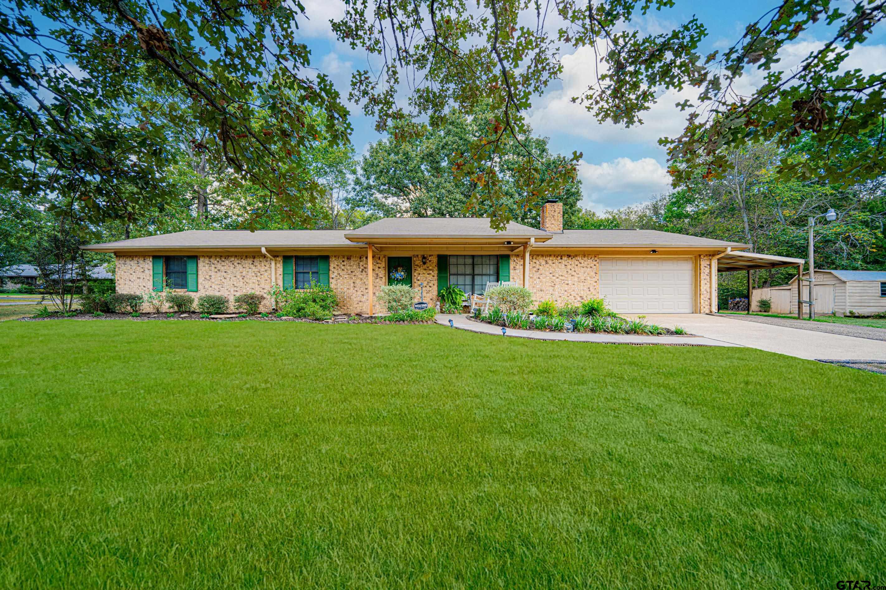 a view of house with yard and outdoor seating