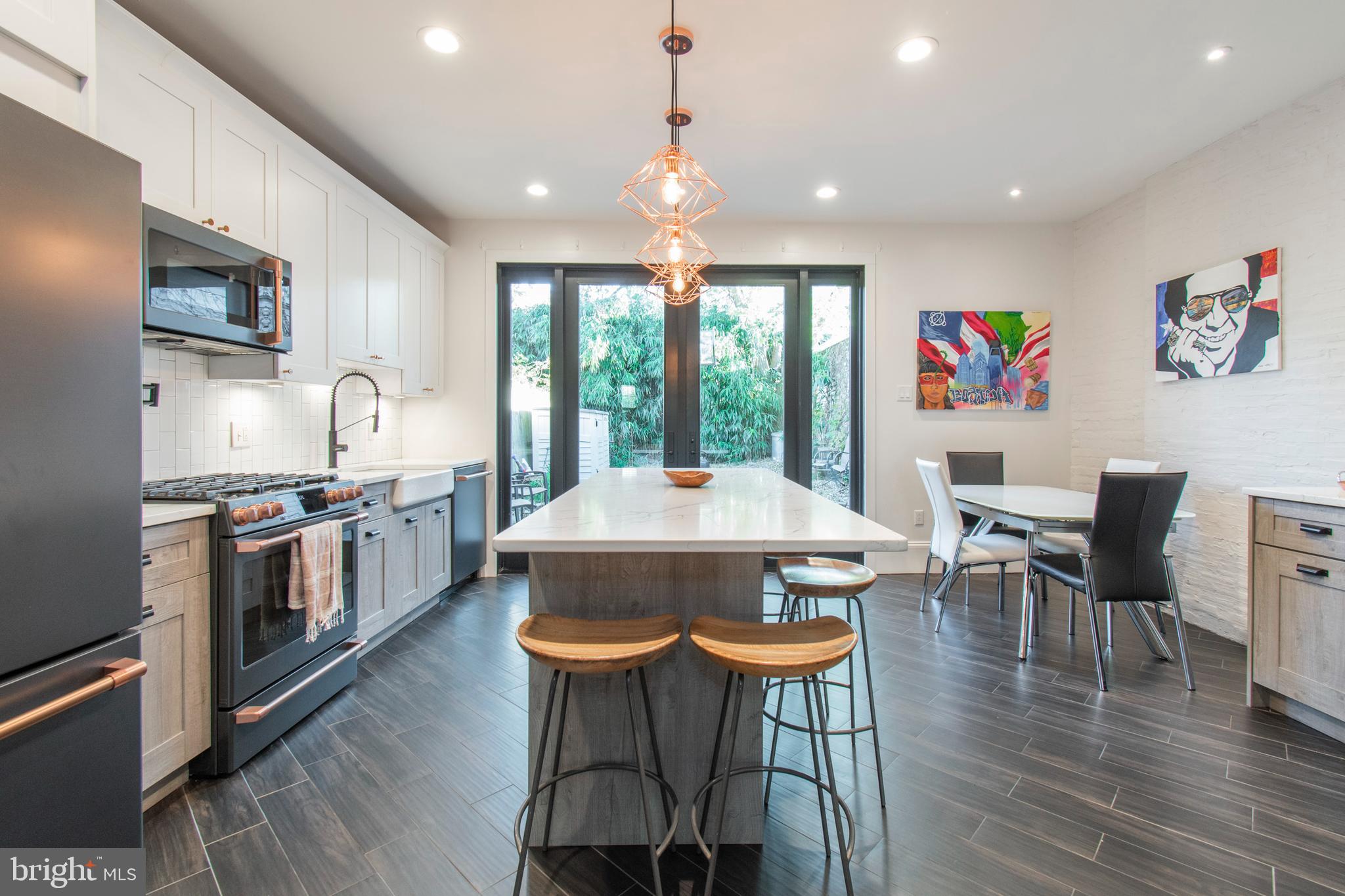 a kitchen with stainless steel appliances a dining table and chairs