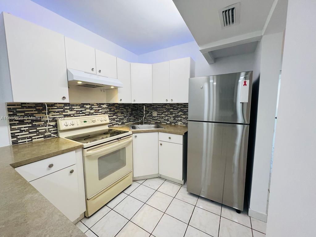 a kitchen with a stove a refrigerator and cabinets