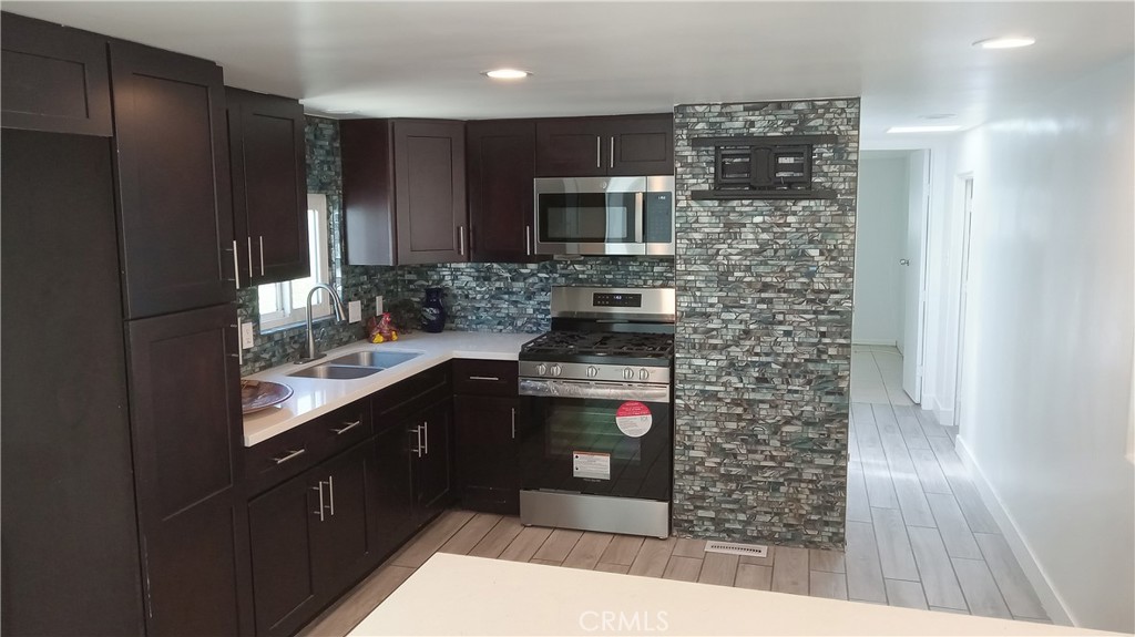 a kitchen with stainless steel appliances kitchen island granite countertop a refrigerator and a stove top oven