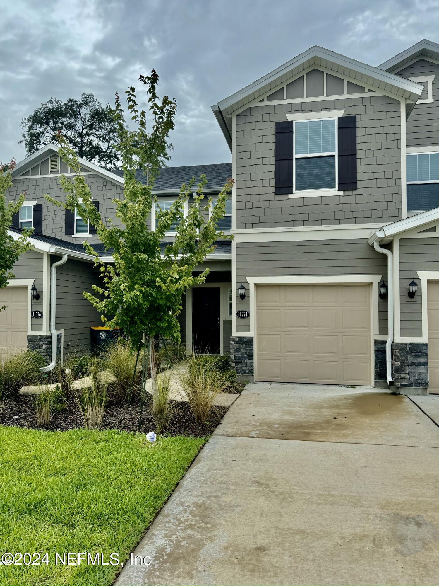 a front view of a house with a garden and plants