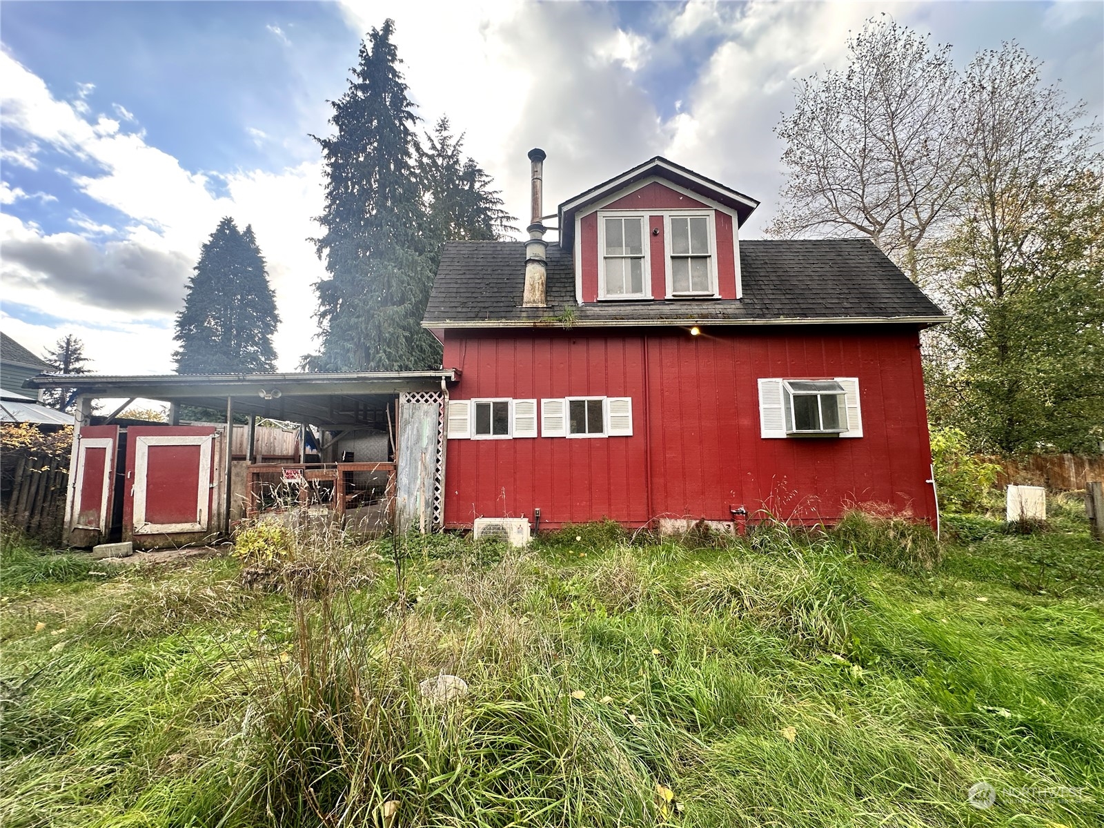 a view of a house with table and chairs in a yard