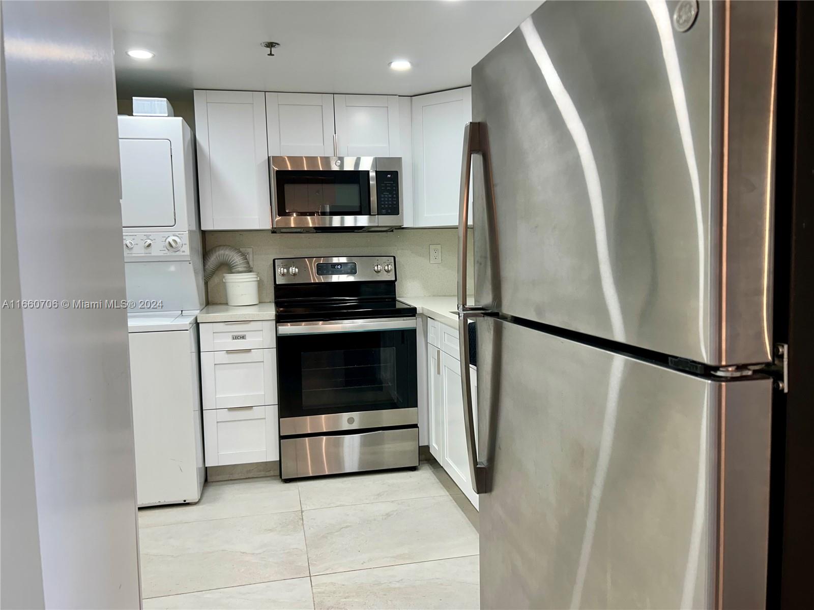 a kitchen with stainless steel appliances a refrigerator sink and microwave