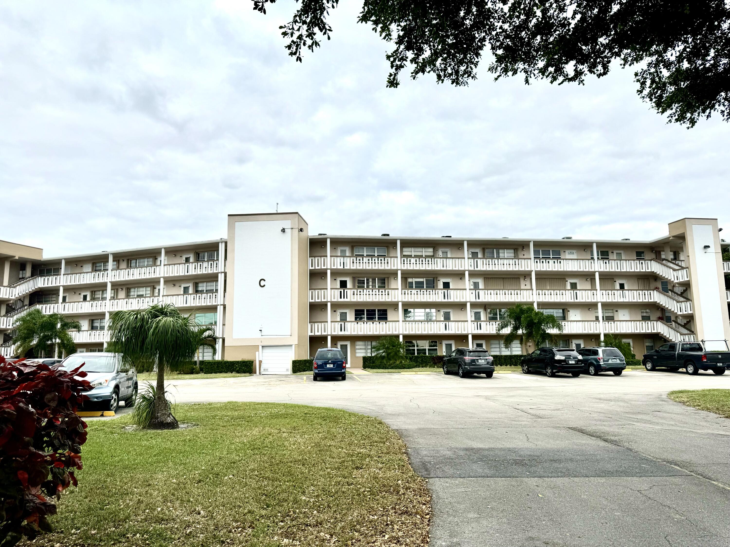 a front view of a building with lot of cars parked