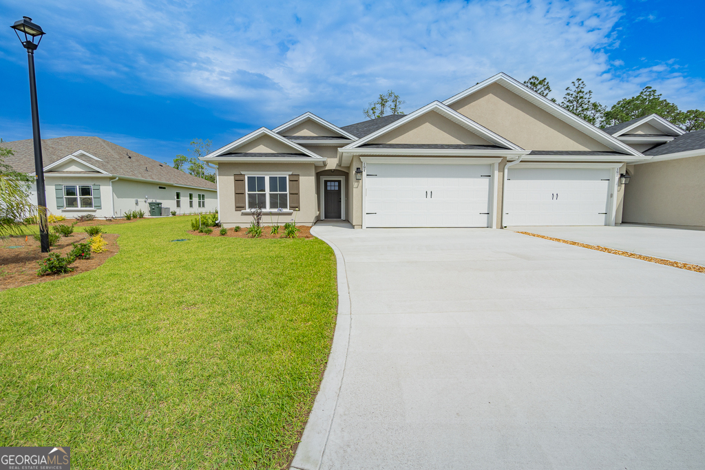 a front view of a house with a garden and yard