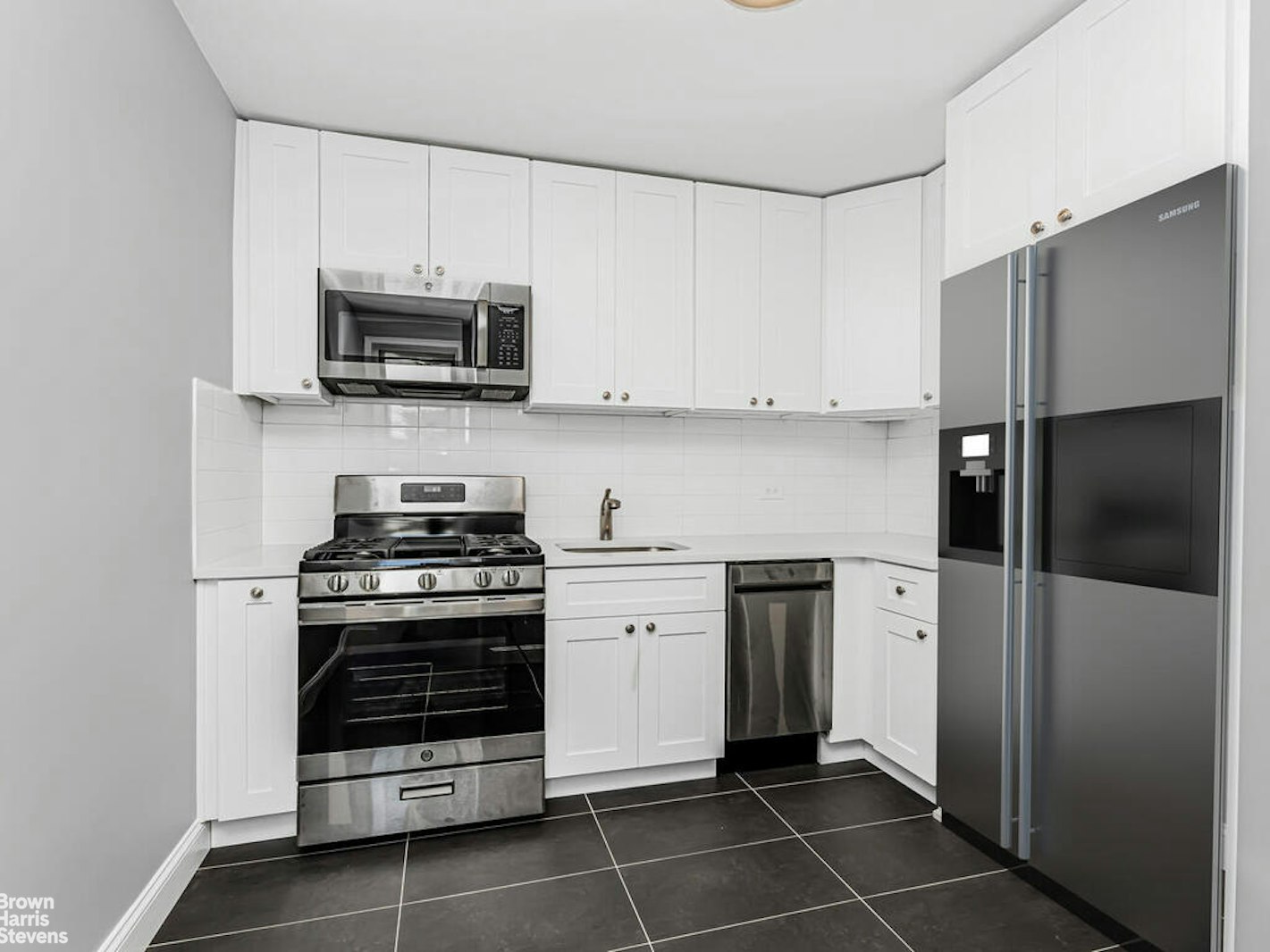 a kitchen with stainless steel appliances and white cabinets