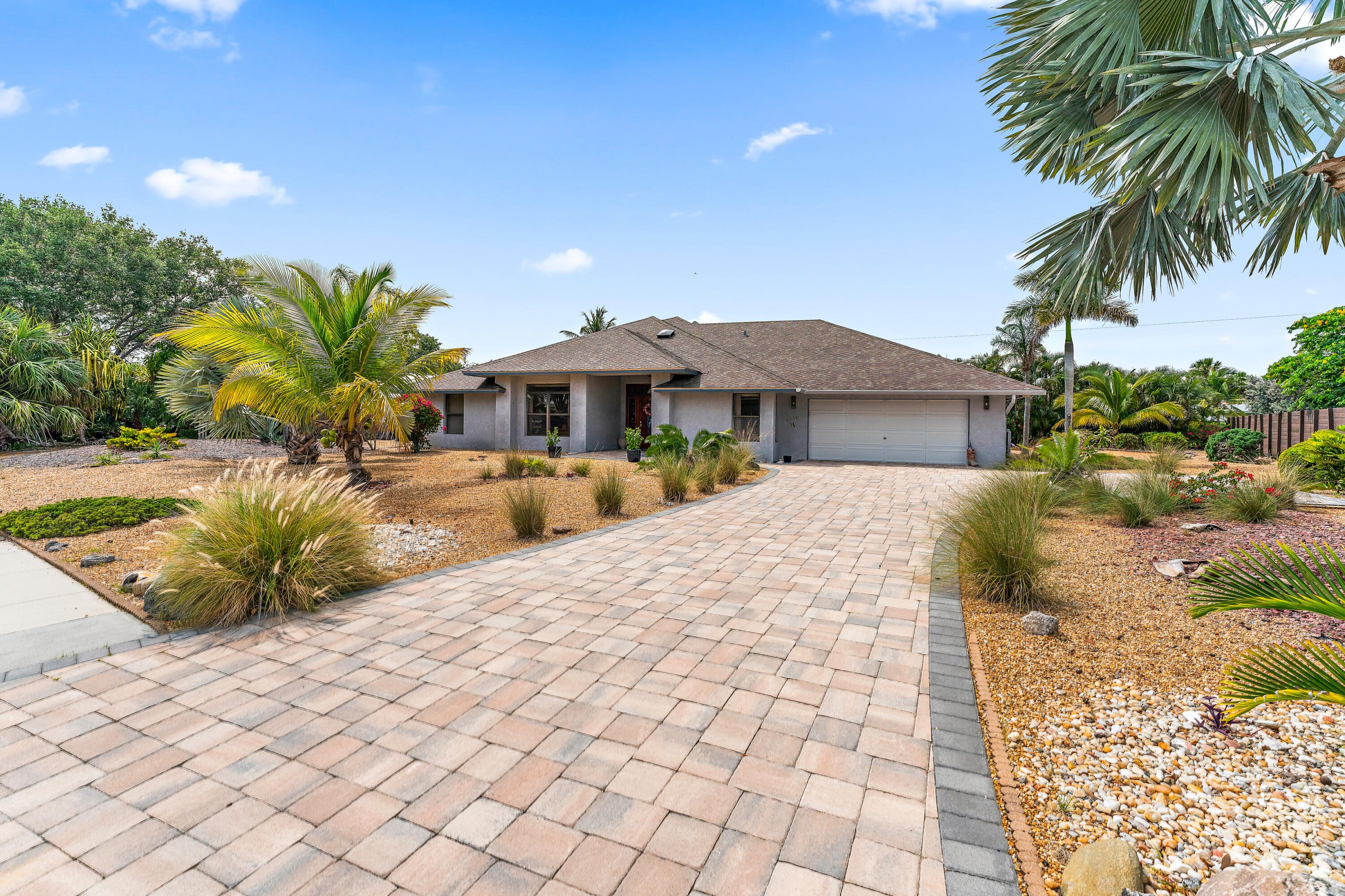 a view of a house with a yard and potted plants