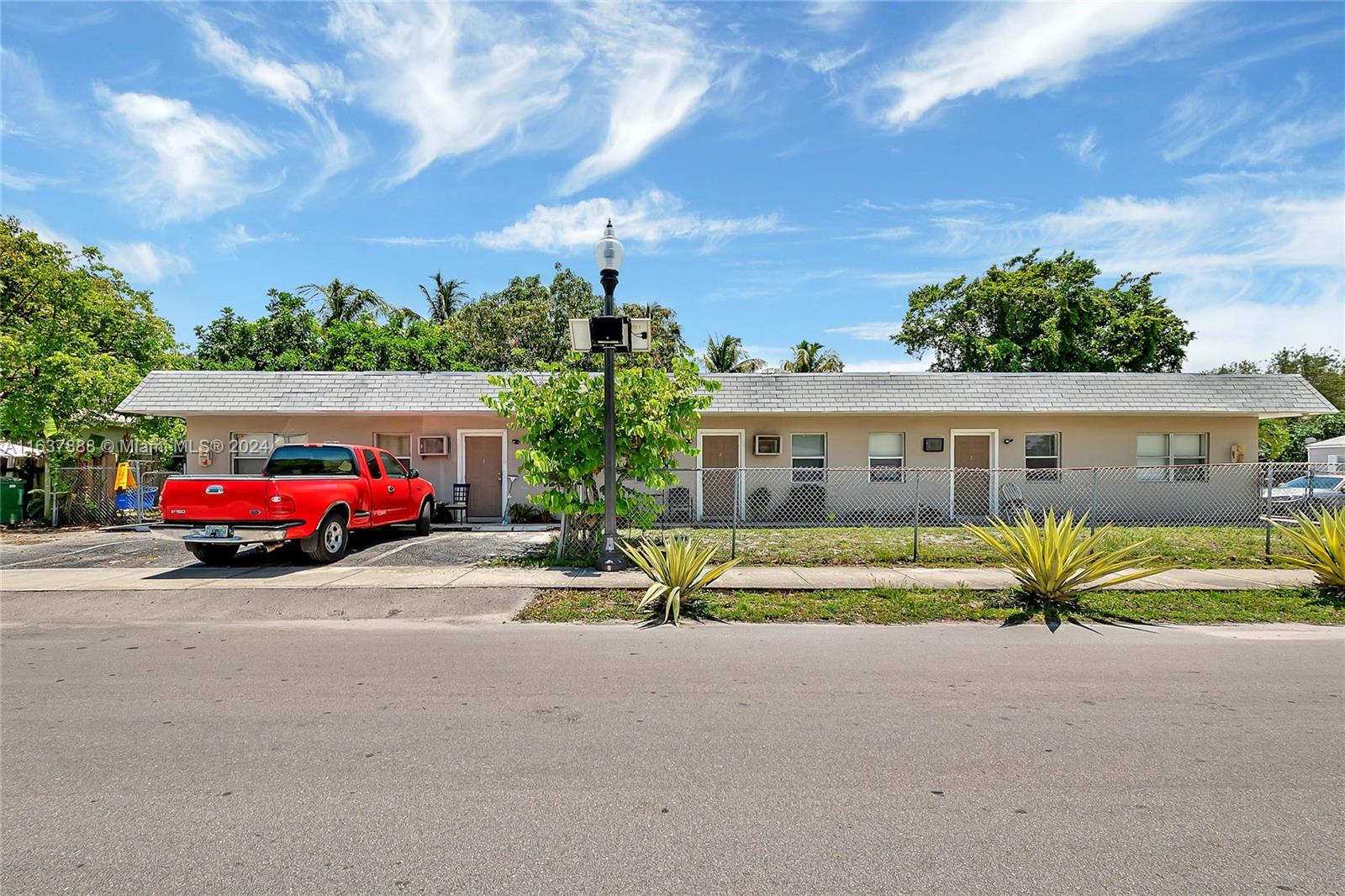 a front view of a house with a garden and parking