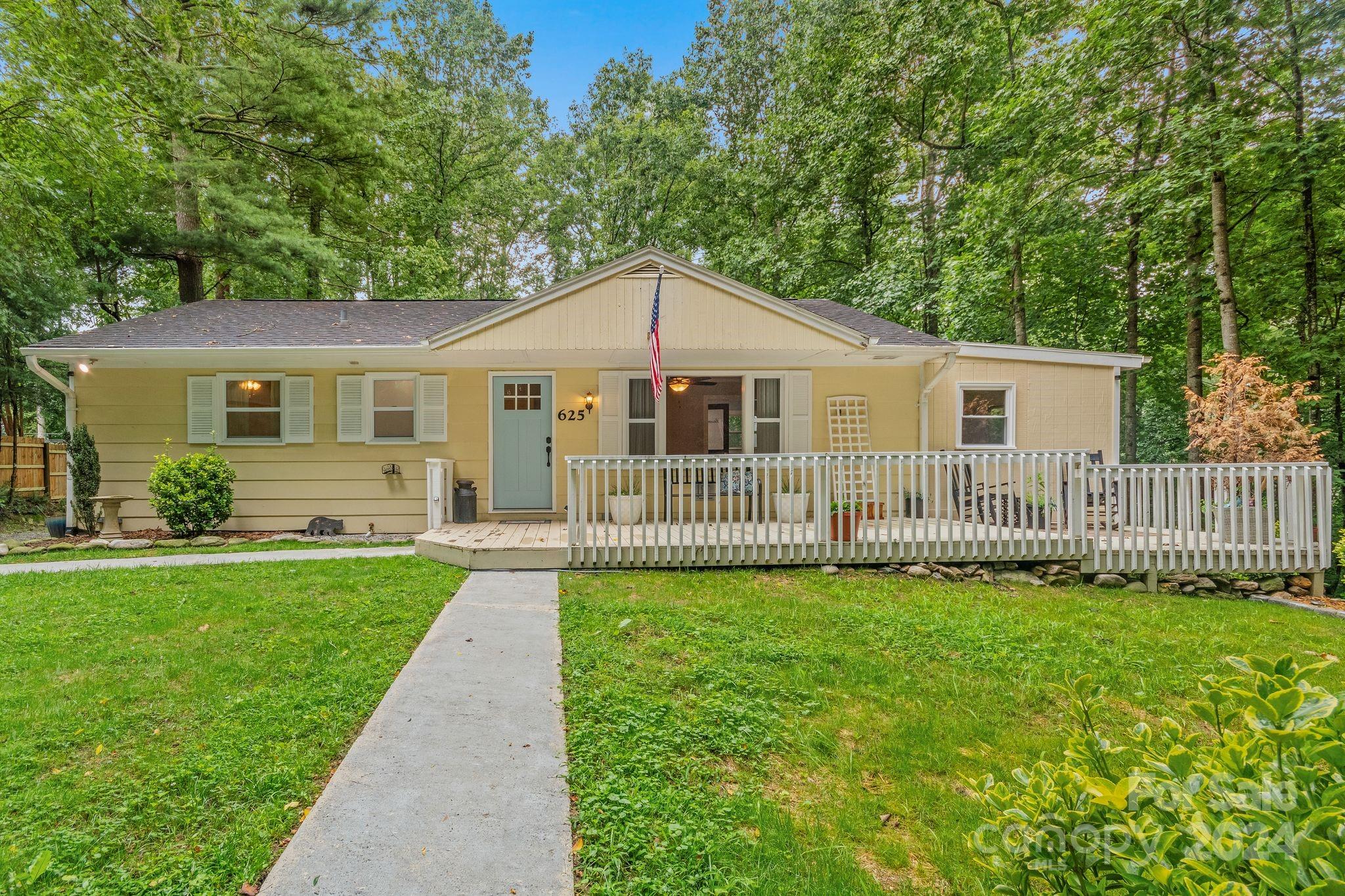 a view of a house with a yard and fence