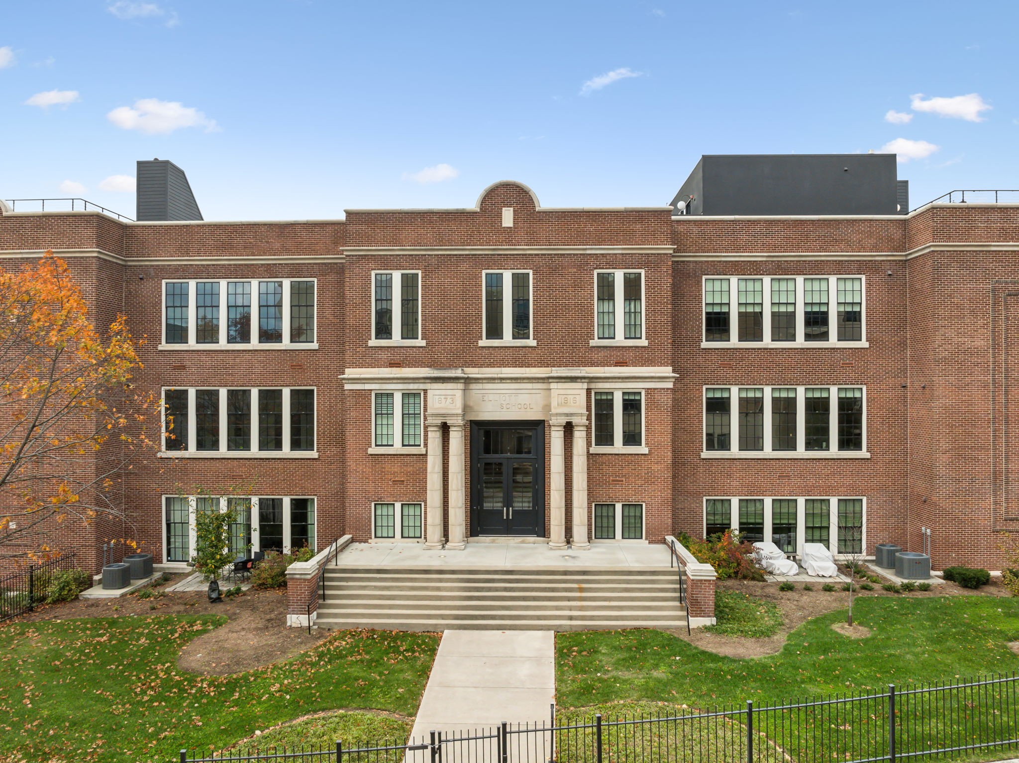 a front view of a residential apartment building with a yard