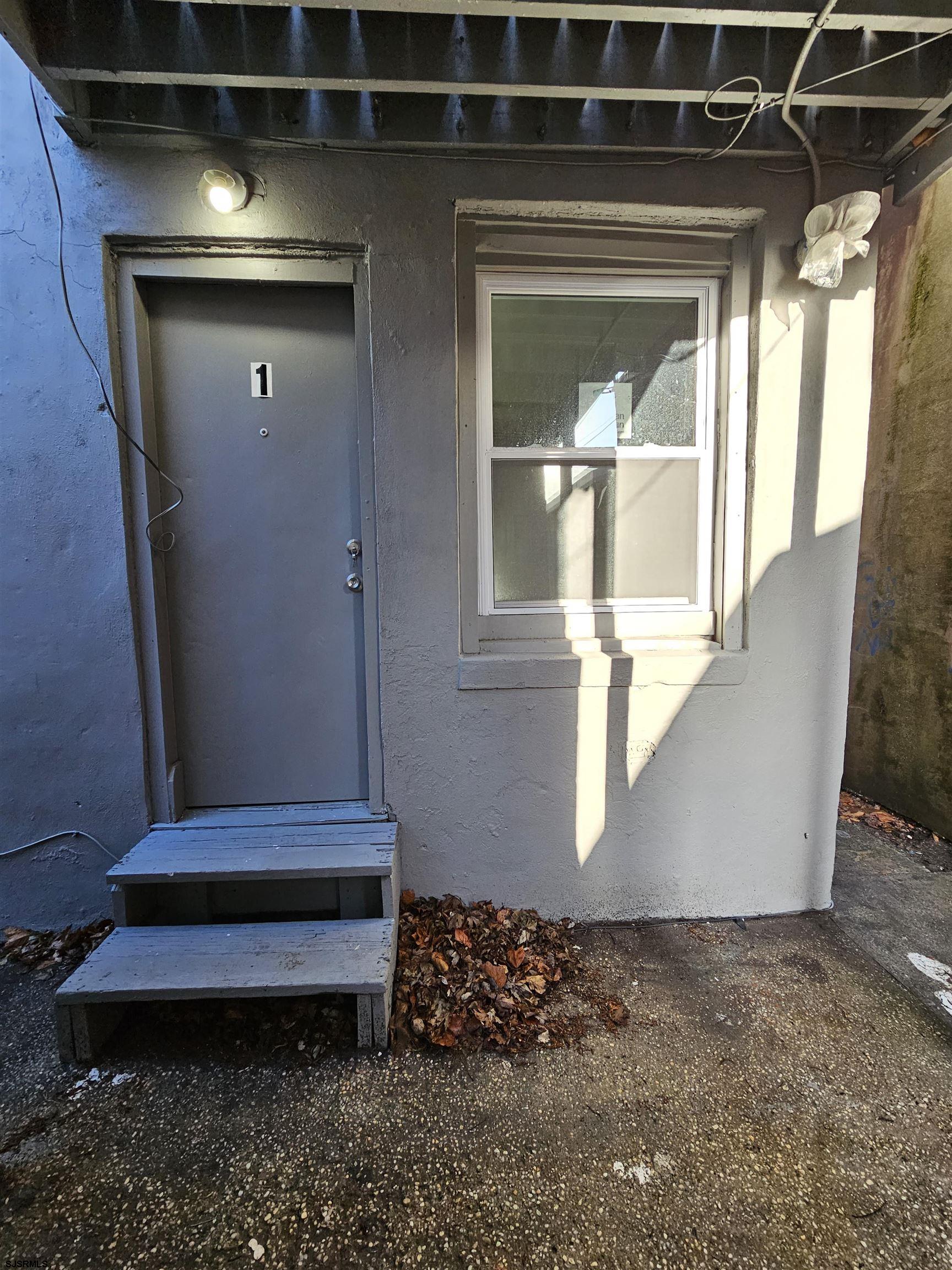 a view of bedroom with window and hallway