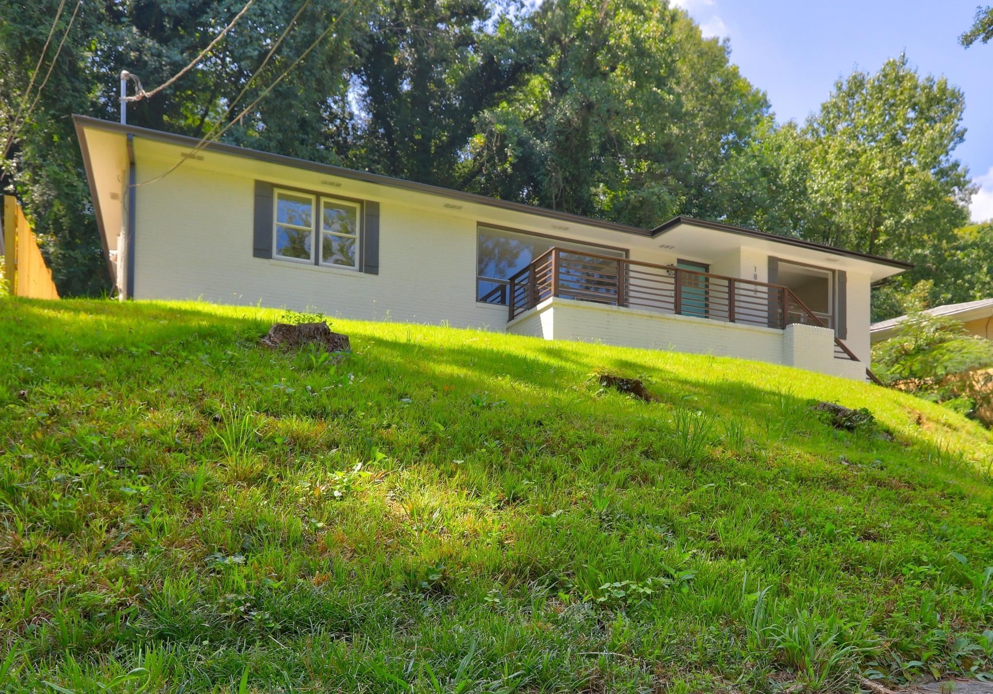 a front view of house with yard and trees in the background