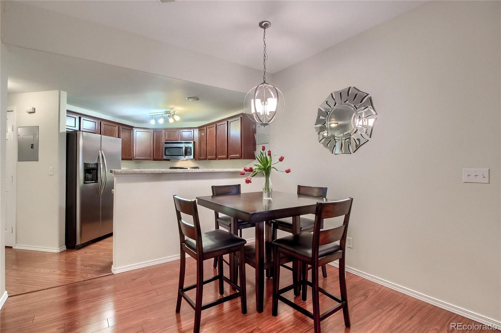 a view of a dining room with furniture a chandelier and wooden floor