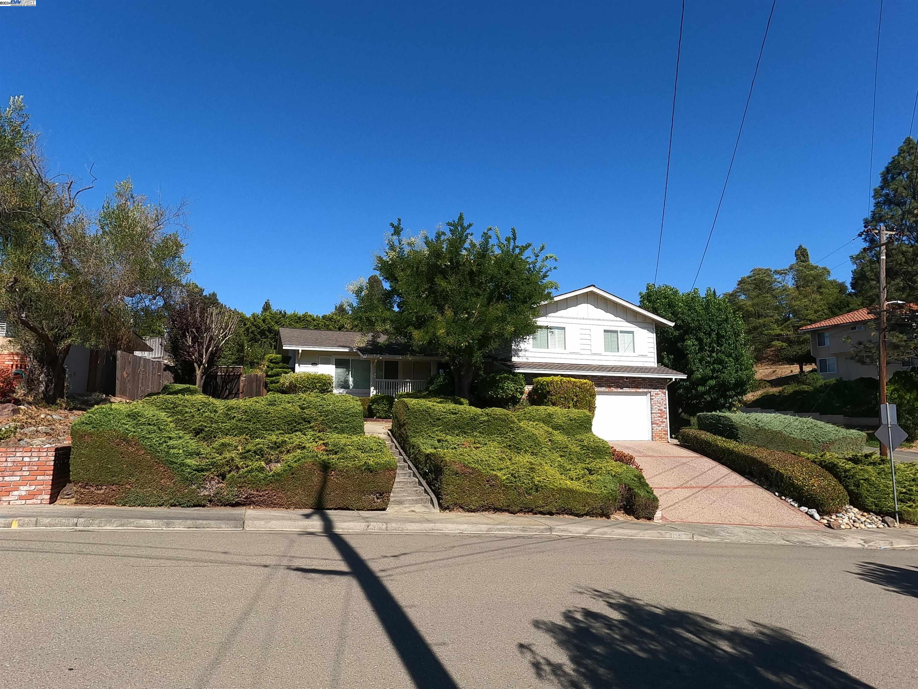 a front view of a house with a yard and trees