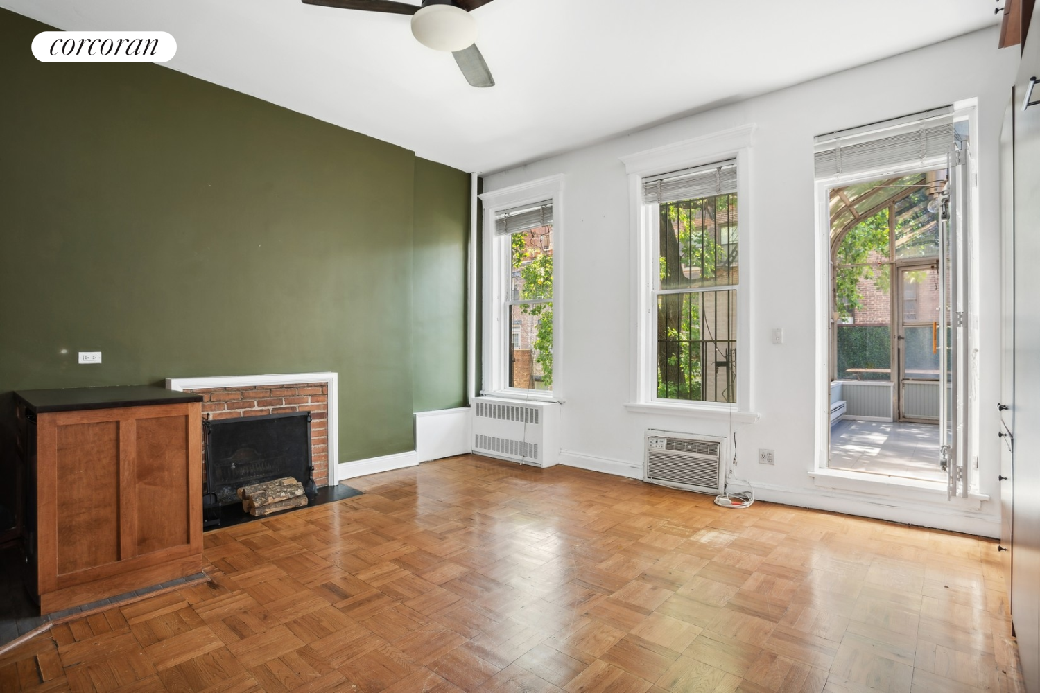 a view of an empty room with a fireplace and a window