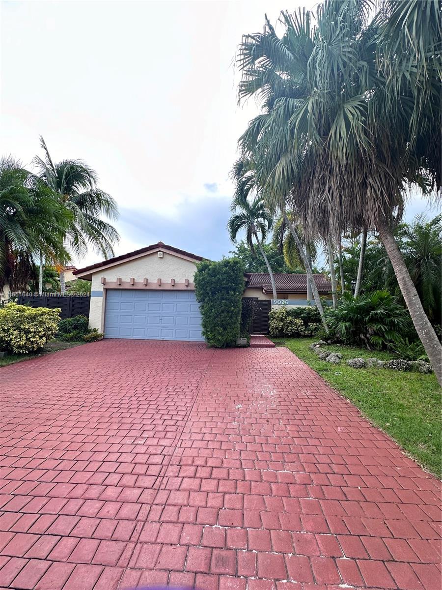 a front view of a house with a yard and a garage