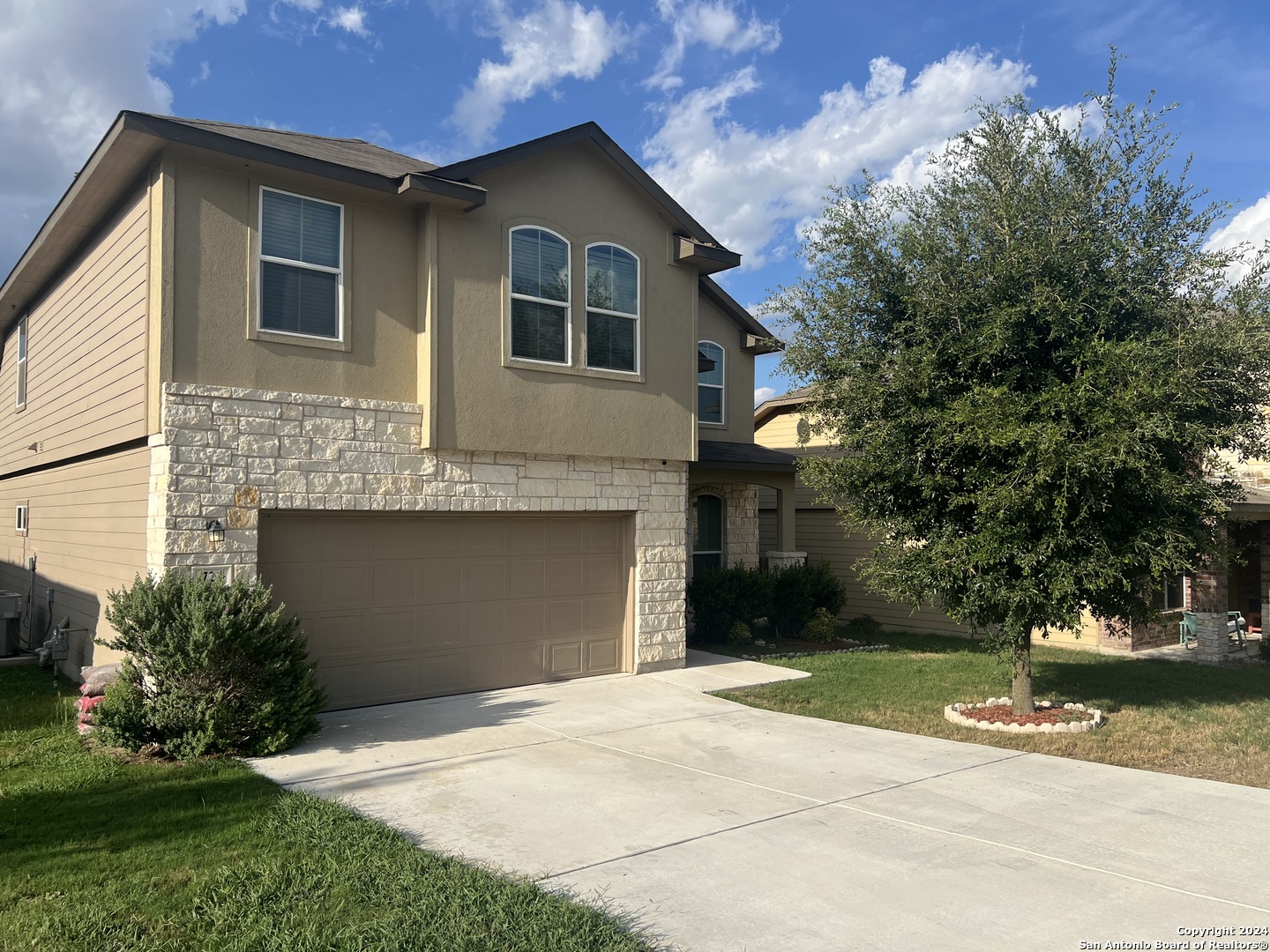 a front view of a house with a yard and a garage