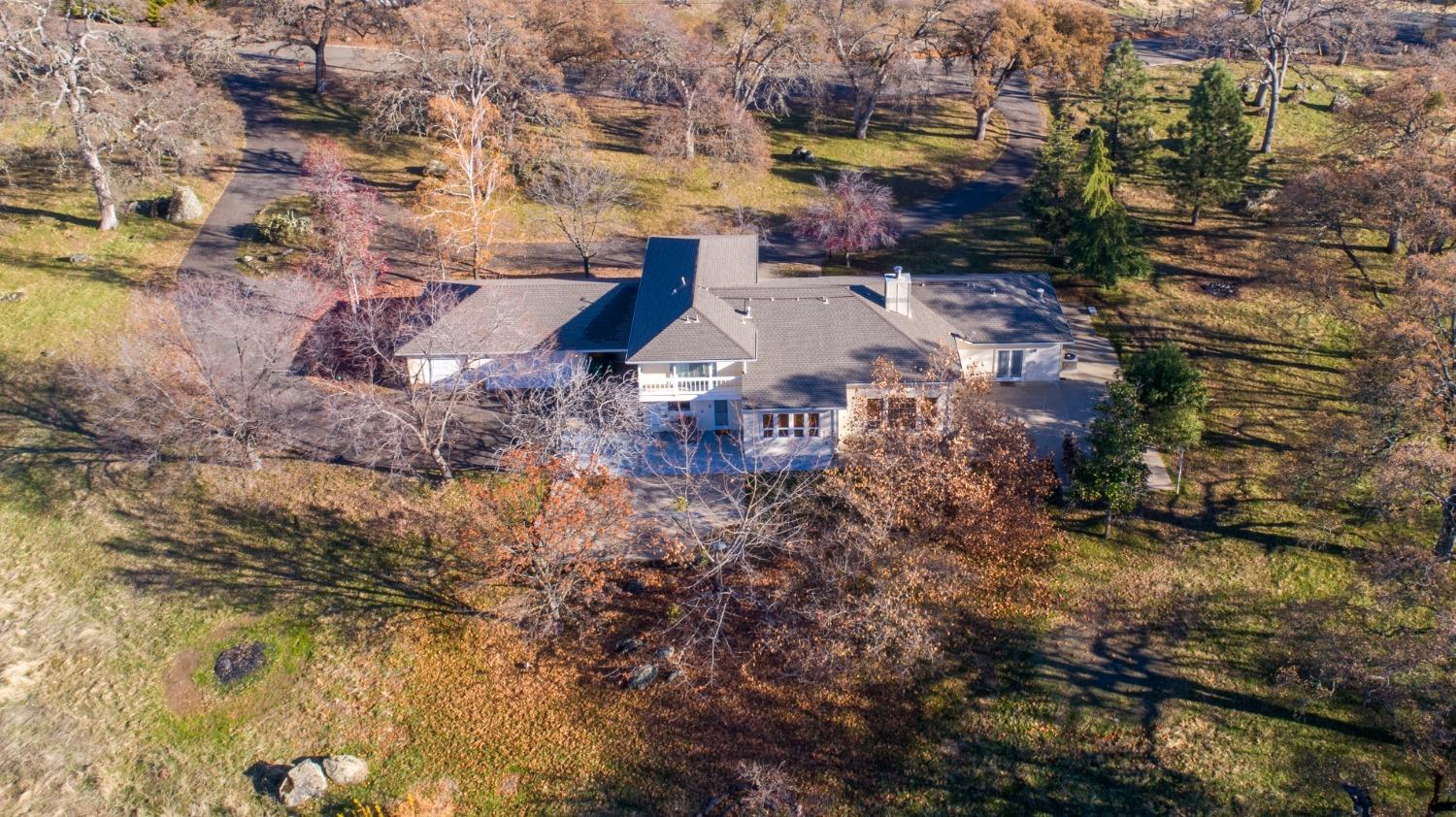 a aerial view of a house with a yard and large tree