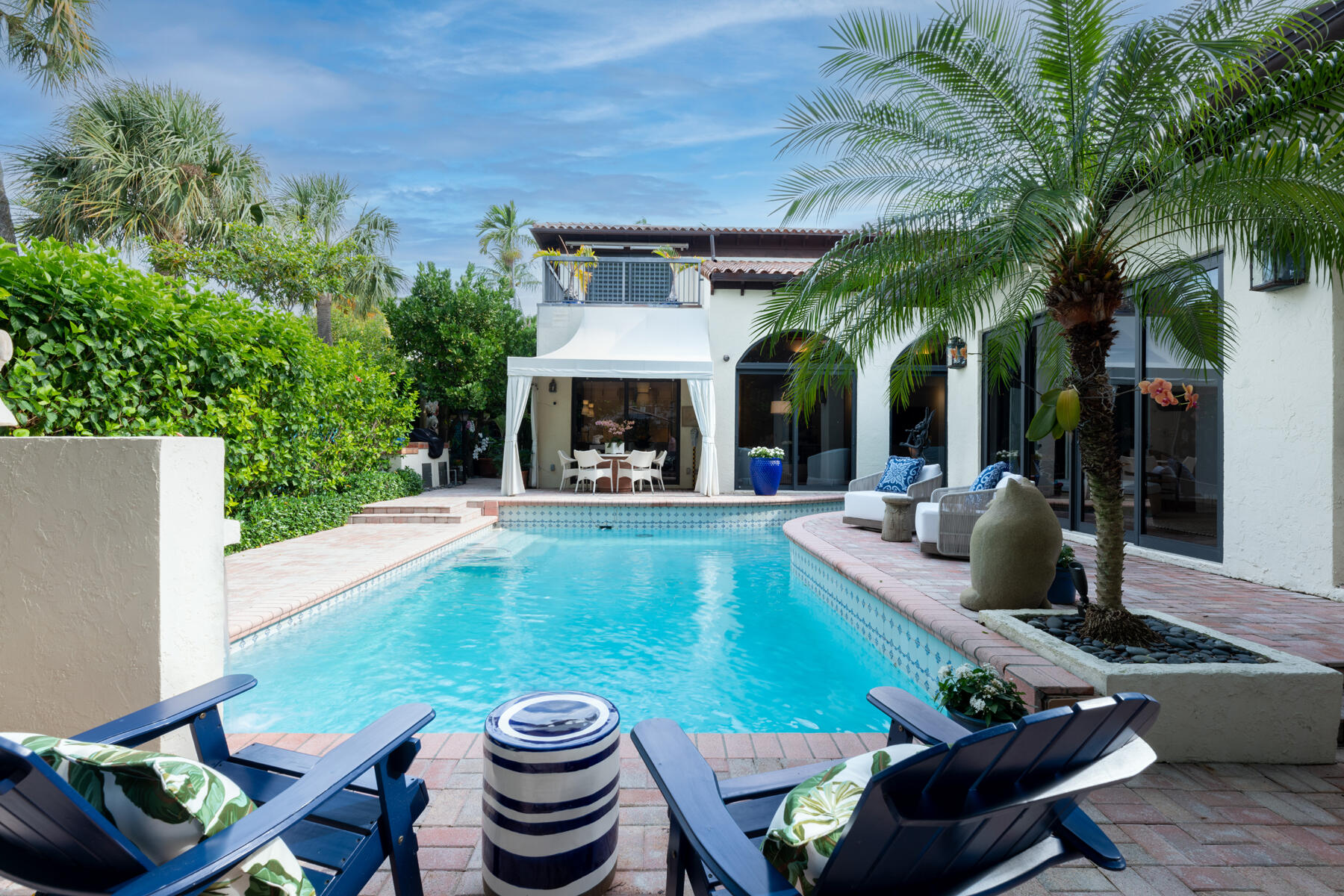 a view of a patio with table and chairs potted plants and palm tree